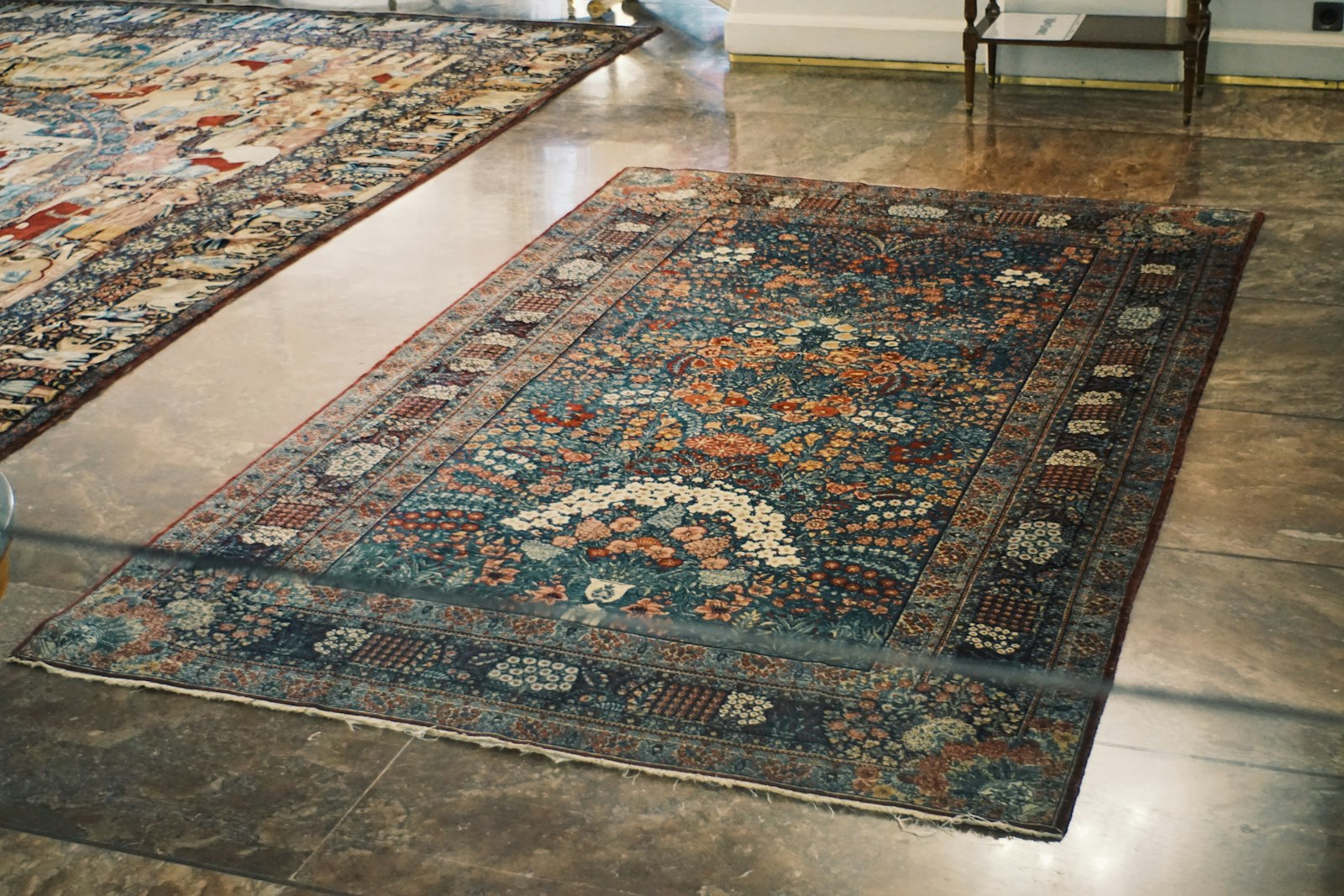 Persian carpet laid on polished marble floor of a showroom hallway